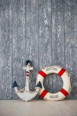 Composition on the marine theme with anchor and lifeline on wooden background
