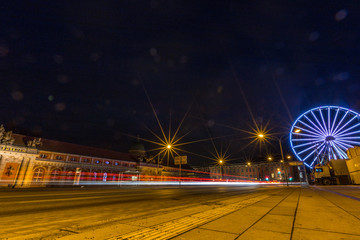 Fototapeta na wymiar Riesenrad und Lichtspuren vorbeifahrender Autos in Potsdam bei Nacht