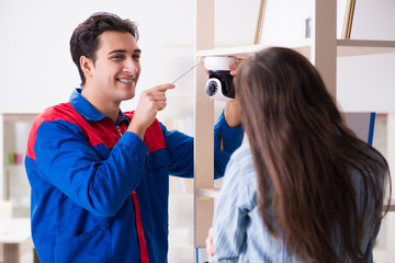 Client getting securty camera installed at home by contractor