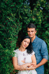 Naklejka premium Young happy couple in love dating in the park. Smiling Man and woman hugging outdoors. Husband and wife having fun outdoors.