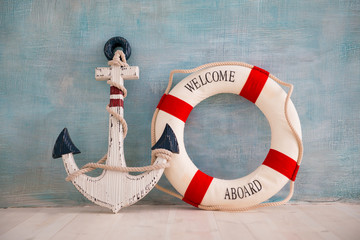 A composition on a sea theme with an anchor and lifebuoy on a blue wall