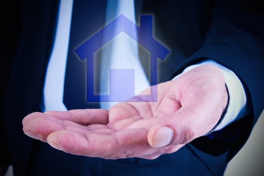 Businessman holding house in hand. mortgage and business concept