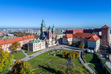 Royal Wawel Gothic Cathedral in Cracow, Poland, with Renaissance Sigmund Chapel with golden dome, part of Wawel Castle, yard, park and tourists. Aerial view in the morning