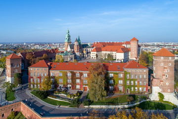 Royal Wawel Gothic Cathedral in Cracow, Poland, with Renaissance Sigismund Chapel with golden dome, Wawel Castle, yard, park and tourists. Aerial view in sunset light