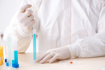 Young chemist student working in lab on chemicals