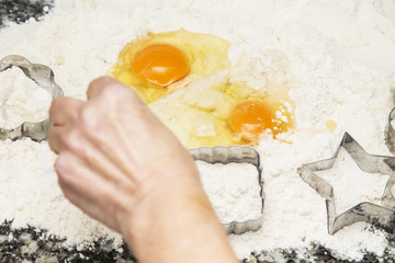 woman making cookies with flour, eggs and molds