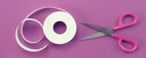 Banner Scissors and a roll of tape white on a purple background.