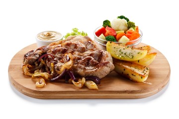 Grilled steak with potatoes on cutting board