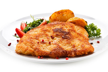 Fried pork chop, baked potatoes and vegetable salad