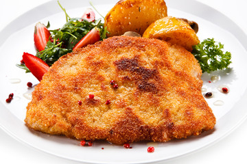 Fried pork chop, baked potatoes and vegetable salad