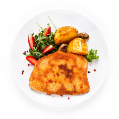 Fried pork chop, baked potatoes and vegetable salad