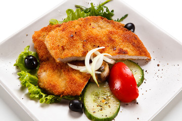 Fried pork chop and vegetable salad on white background