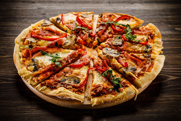 Pizza with ham and vegetables on wooden table