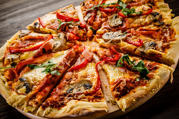 Pizza with ham and vegetables on wooden table