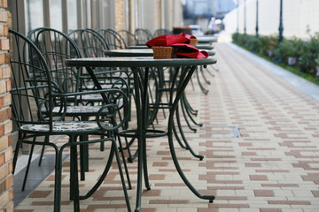 Tables and chairs arranged behind the sidewalks of the city