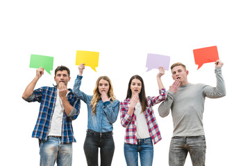 Obraz premium The four surprised people hold dialog signs on the white background