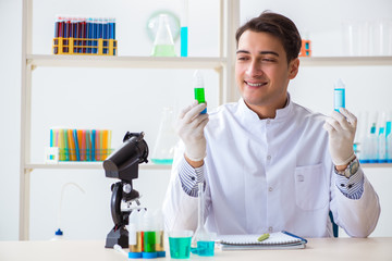 Young chemist student working in lab on chemicals