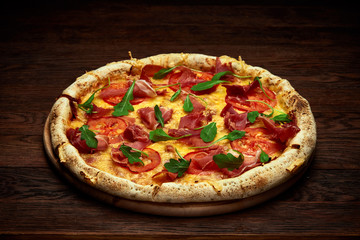 Delicious italian pizza margherita served on wooden plate over rustic wooden background