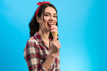 The cute woman eating an ice cream on the blue background