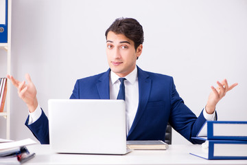 Young handsome businessman employee working in office at desk