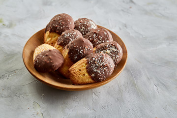 Freshly baked almond cookies piled on ceramic plate over white background, top view, close-up, selective focus