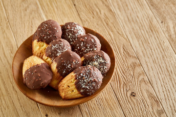 Freshly baked almond cookies piled on ceramic plate over rustic background, top view, close-up, selective focus