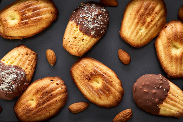 Freshly baked almond cookies on cooking tray over wooden background, top view, selective focus.