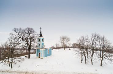 small blue chapel with snow