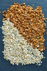 Healthy mix of granola and oatmeal on dark background, top view, close-up, selective focus