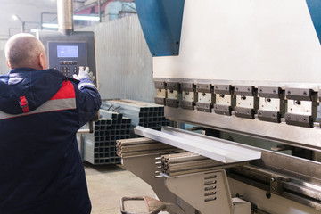 Operator working cut and bending metal sheet by high precision metal sheet bending machine, cnc control metal sheet bending machine in factory