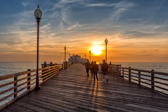 People walking on Oceanside pier at sunse, California