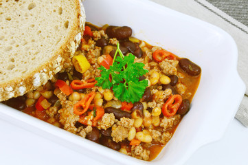 chili con carne on white bowl and Black bread or Rye bread