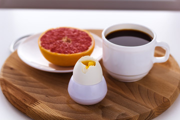 healthy breakfast fresh  hard boiled egg,  coffee cup and grapefruit