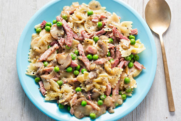 Creamy ham & mushroom farfalle. Carbonara pasta with ham, mushroom, peas in rich cream and cheese sauce. 