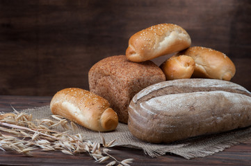 Bread with ear and textured fabric on wooden background