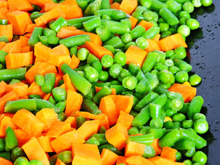Sliced vegetables before baking on the Pan for baking. Carrots, green peas, green beans. The concept of a healthy diet.