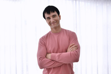 Obraz premium Portrait of young man indoors with very handsome face in pink casual shirt on bedroom