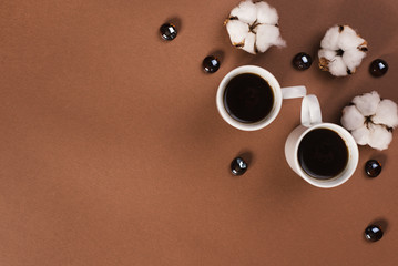 Two cups of coffee with glass drops on the brown background