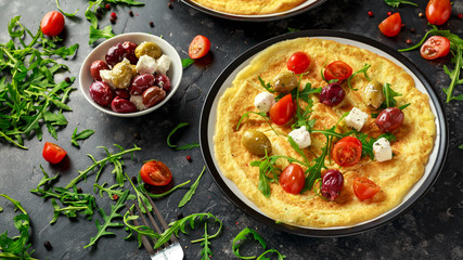 Vegetables Eggs Omelette with tomatoes, wild rocket, greek cheese, olives in a plate. Morning breakfast. healthy food