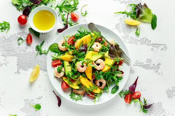Fresh Avocado, Shrimps, Mango salad with lettuce green mix, cherry tomatoes, herbs and olive oil, lemon dressing. healthy food