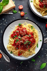 Spaghetti pasta meatballs with tomato sauce, basil, herbs parmesan cheese on dark background