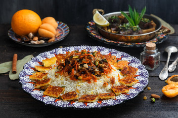 Iranian wedding pilaf topped with nuts, orange zest and raisins, rustic style