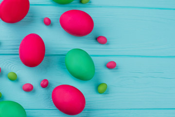 Easter dyed eggs, copy space. Painted Easter eggs and candies on blue background. How to dye Easter eggs.