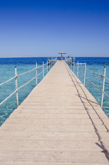 Obraz premium Wooden bridge over the sea. Travel and Vacation. Red sea, Sharm El-Sheikh