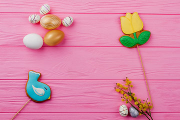 Obraz na płótnie Canvas Festive Easter background and copy space. Easter glazed cookies, decorative eggs and pussy willow twig. Spring and feast.