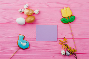 Easter composition and blank paper card. Spring Easter festive decor on pink wood. Idea of Easter greeting.