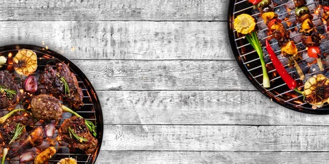 Zelfklevend behang Grill / Barbecue Bovenaanzicht van vers vlees en groente op de grill geplaatst op hout
