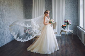 Beautiful bride in wedding dress with lace. The wedding veil flies like in the wind. Studio....