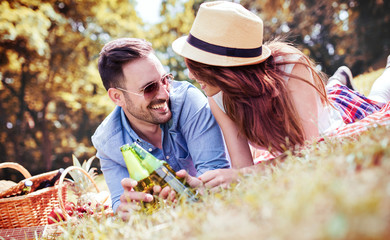 Naklejka na ściany i meble Couple enjoying picnic together. Love and tenderness, dating, romance, lifestyle concept