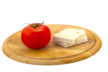 Cheese served with tomatoes on wooden  board on the table